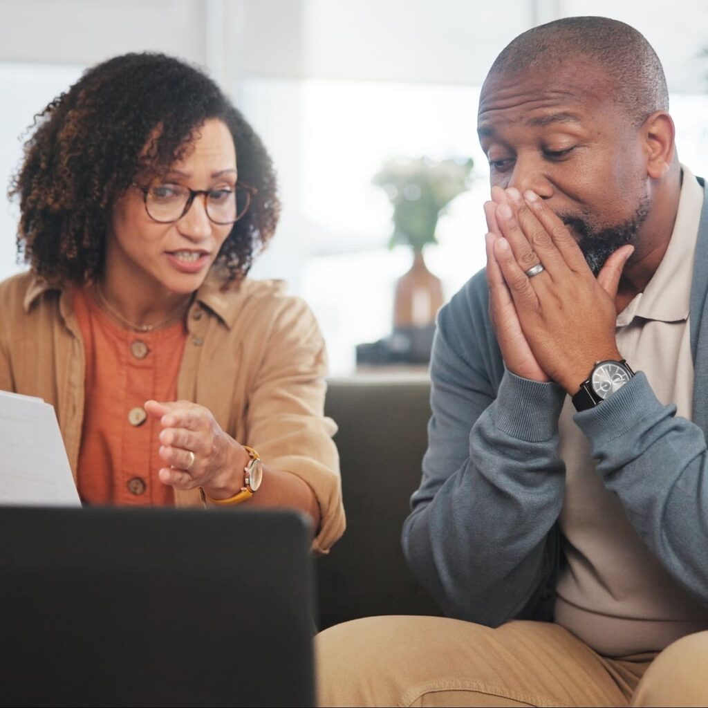 Worried African American couple looking at a laptop